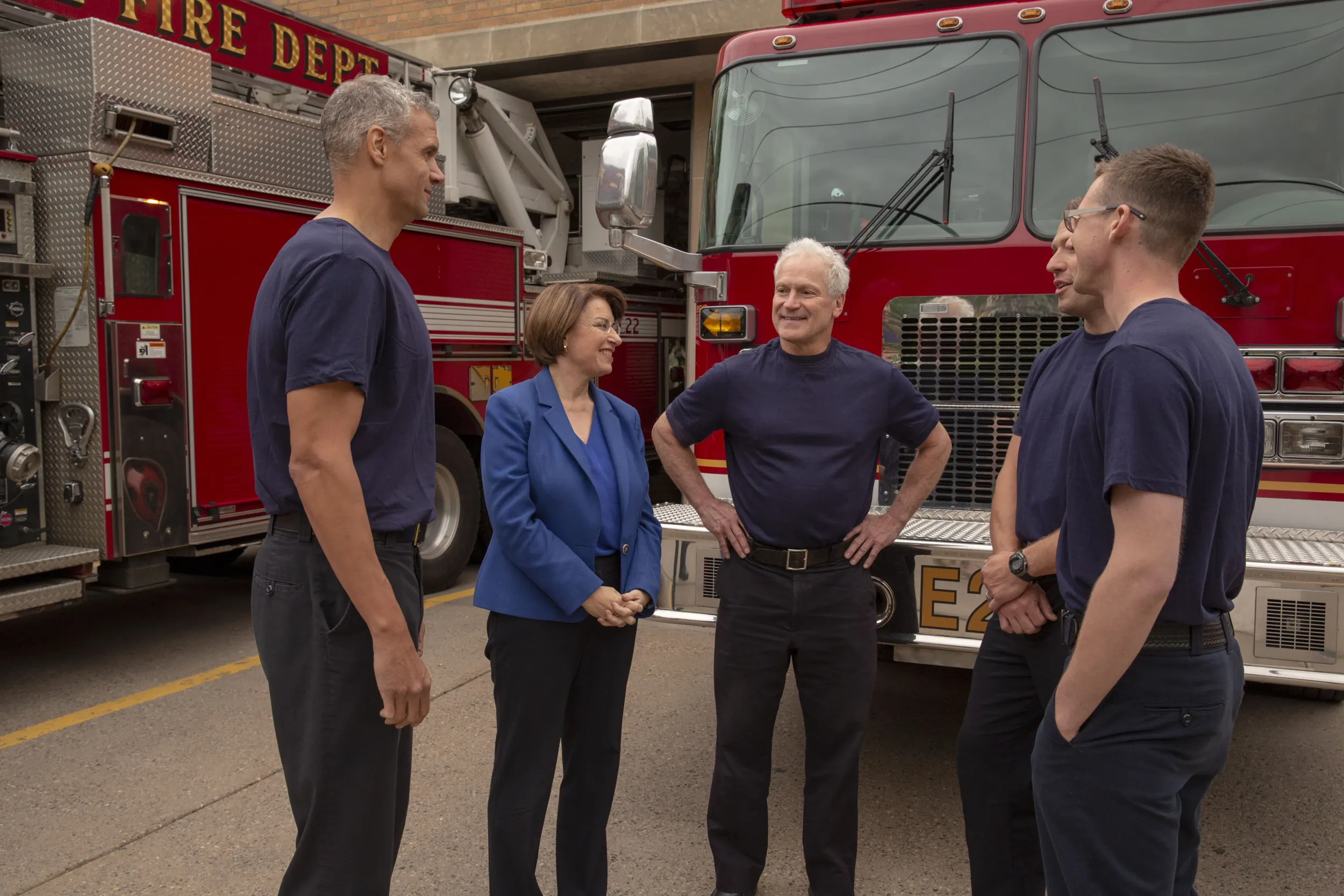 Amy Klobuchar standing with firefighters