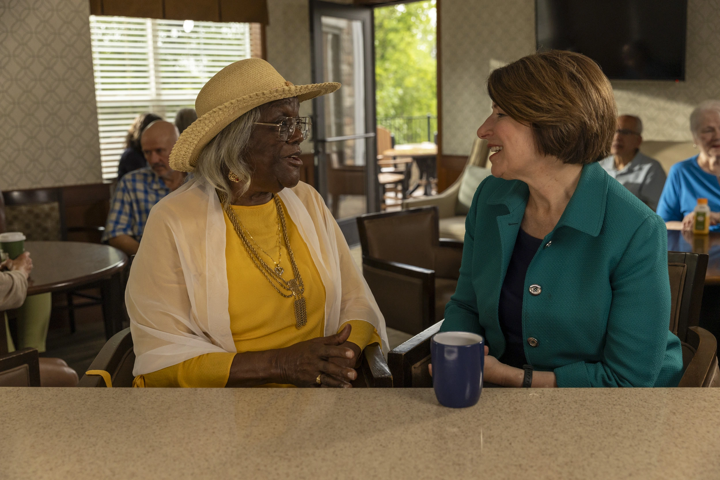 Amy Klobuchar in conversation during a senior living visit